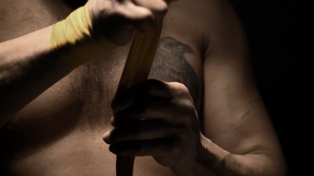 Native American athlete wraps his hand with yellow tape. Close up shot.