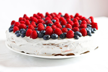 Creamy sweet cake with blueberries and raspberries