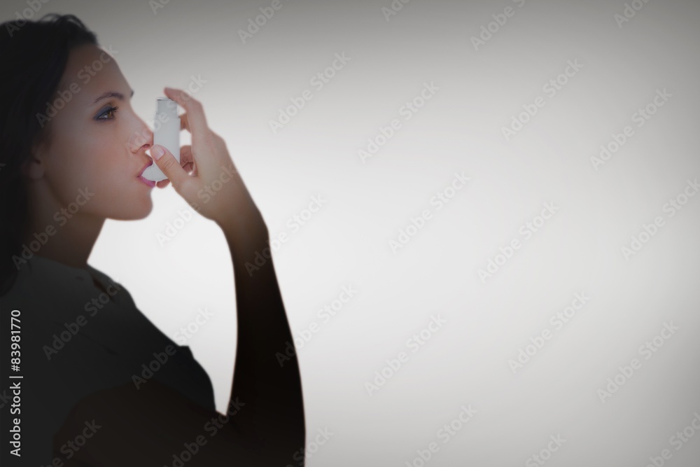 Poster Composite image of asthmatic brunette using her inhaler 