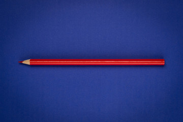 Red pencil on blue paper