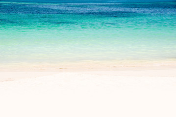 Fototapeta na wymiar Edge of a beach with turquoise water and white sand