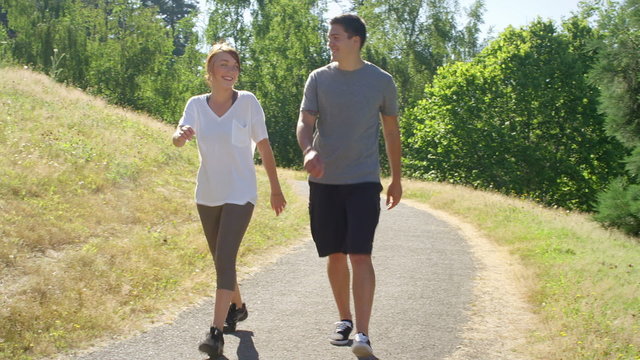 Fit and healthy young couple walks through the park