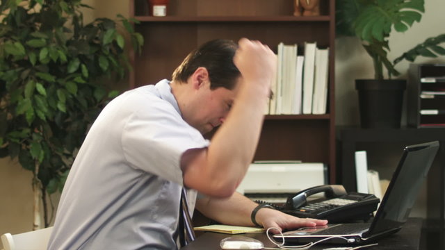 Slow motion of an angry businessman punching his computer