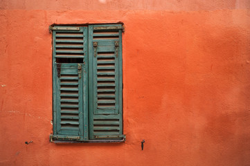 green window shutters on orange texture wall