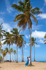 Beach couple walking on romantic travel near high palms.