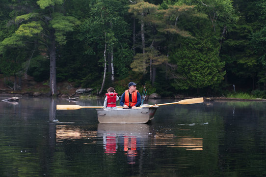 Father And Son Out Fishing In A Row Boat