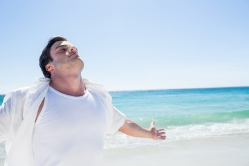 Man stretching his arms in front of the sea