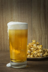 Beer Glass and Popcorn on a Wooden Background