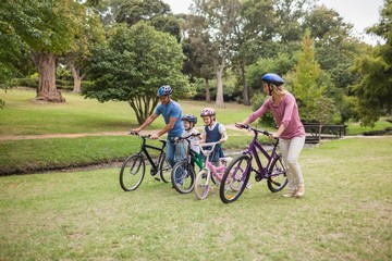 Obraz premium Happy family on their bike at the park 