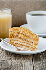 Tasty honey cake with jar of honey.