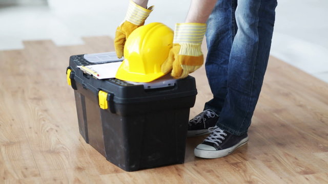 close up of man carrying tool box and leaving