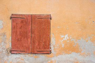 solid closed wooden window shutters on grunge wall background
