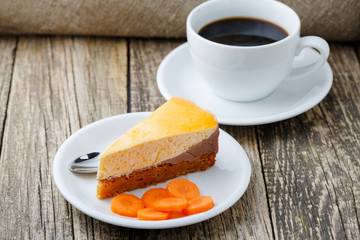 Sweet slice of carrot cake with coffee cup.
