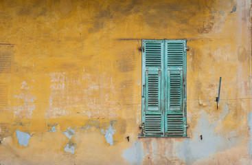 old grungy wall and window shutters in old town Nice,France