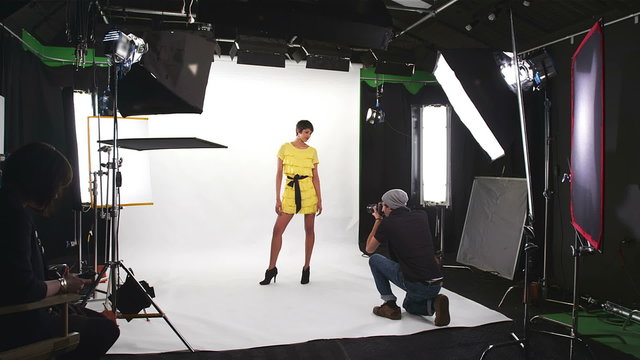 Photo shoot on white inside a studio. Wide dolly shot