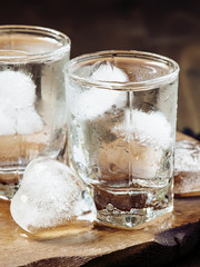 Cold fresh water with ice in a heart shape in the misted glasses
