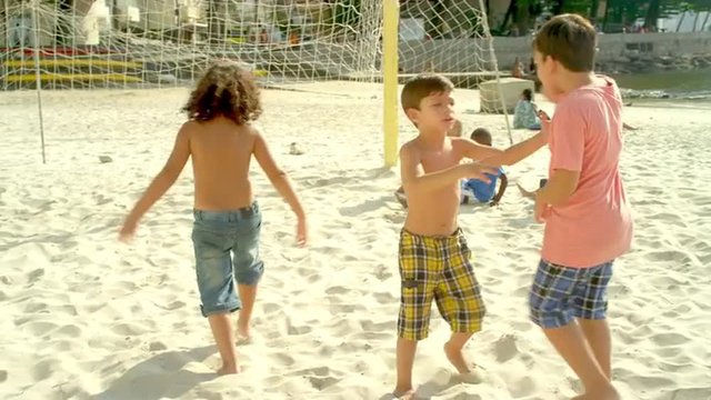 Kids playing soccer on a beach in Brazil