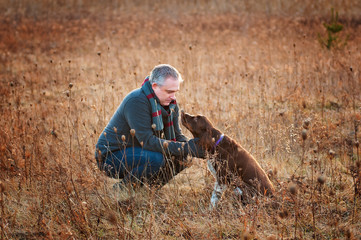 man in a field with his springer spaniel dog