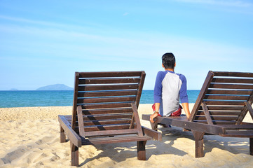 man sit on beach chair on sand beach. 