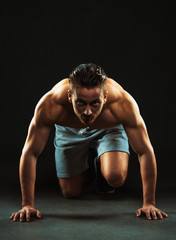 Sport attractive man doing fitness exercises on the black