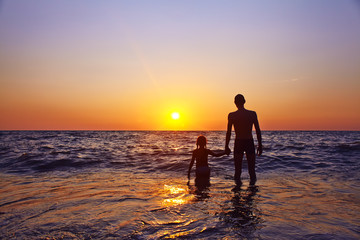 father and daughter at sunset