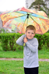 Outdoor portrait of adorable little blond boy with umbrella