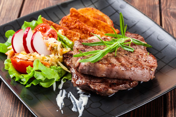 Portion of beef steak served with roast potatoes
