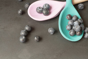 blueberries and wooden spoon on a wooden tray
