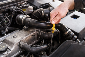 Mechanic checks the oil on a car being repaired