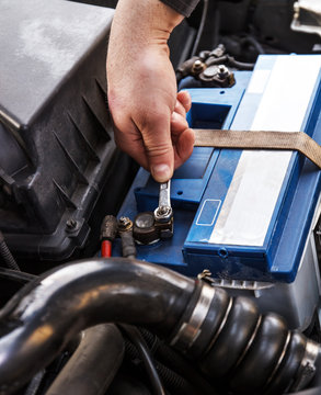 Fitting a battery to a car in a garage, Close-up