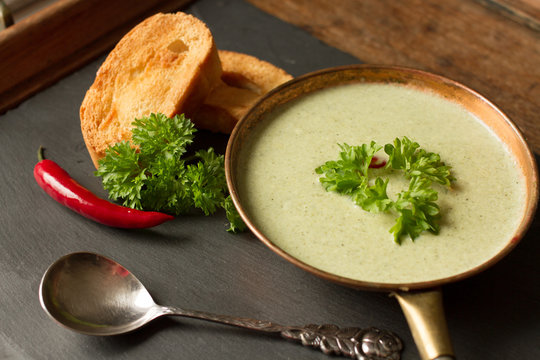 broccoli soup with toasted bread on a black background