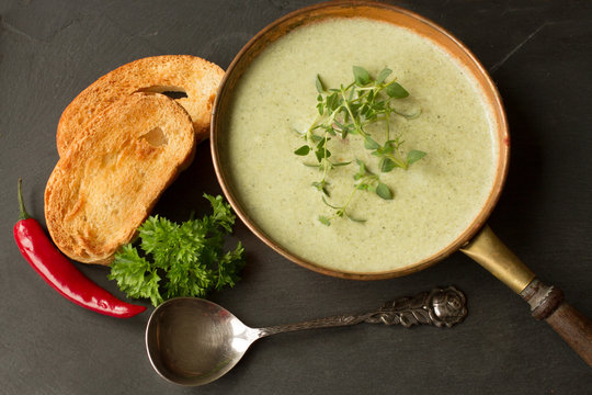 broccoli soup with toasted bread on a black background