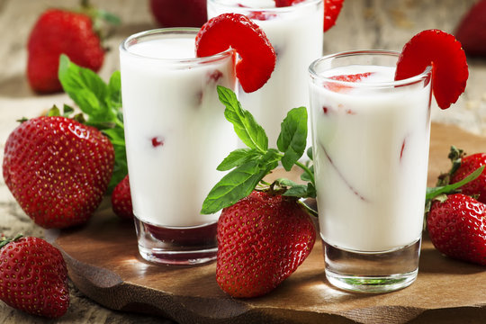 Strawberry milk in glass jars in a rustic style, selective focus