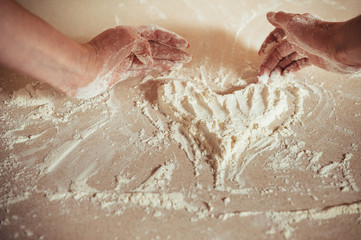 Fototapeta premium Woman holding dough heart in his hands