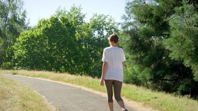 Fit and healthy young woman walks through the park