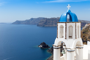 Fototapeta na wymiar Blue and white church of Oia village on Santorini island. Greece
