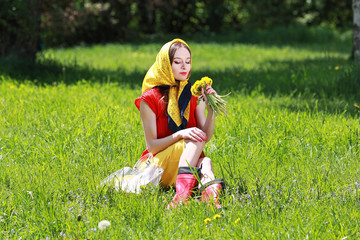 девушка сидит на траве в парке и нюхает букет полевых цветов © prohor08