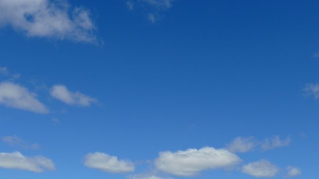 Clouds Drift Gracefully Through Blue Sky, Time Lapse
