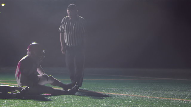 A football player gets a hand off and jumps over the pile to score a touchdown