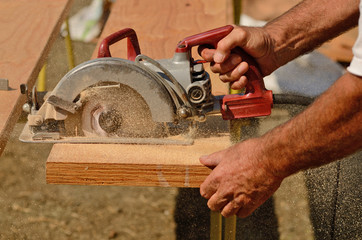 held worm drive circular saw to cut boards