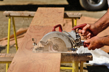 held worm drive circular saw to cut boards