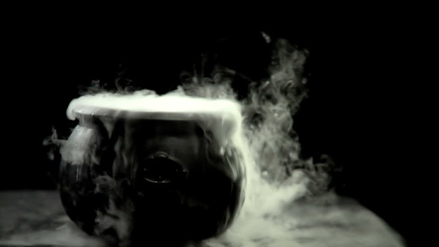 A Cauldron steams on a black background