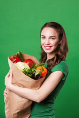 beautiful happy woman holding a grocery bag full of fresh and