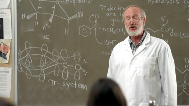 A university chemistry professor gives a lecture to his class