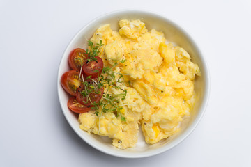 Aerial view tasty fresh scrambled eggs on plate white background - 84012783