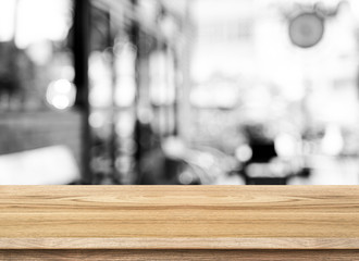 Empty wood table top with coffee shop blur with bokeh background