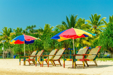 Exotic sandy beach with sun umbrellas and chairs