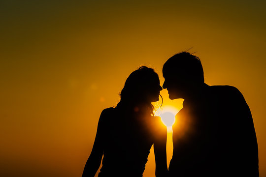 Young couple in love meet sunrise (sunset) on the coast