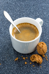 cup of coffee and almond biscuits on a dark background, top view