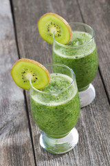 fruit and vegetable green smoothie on a wooden table, top view